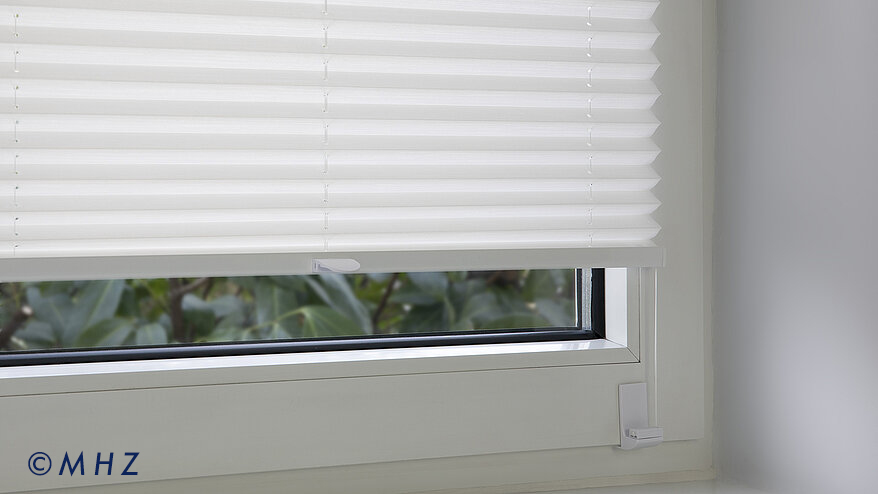 csm_mhz-plissee-montageart-winkeltraeger-am-fensterrahmen_7ec043e12a Montageart Winkelträger: Nahaufnahme der Befestigung eines Plissees am Fensterflügel mittels eines stabilen Winkels, der die Spannschnur vor dem Rahmen hält.